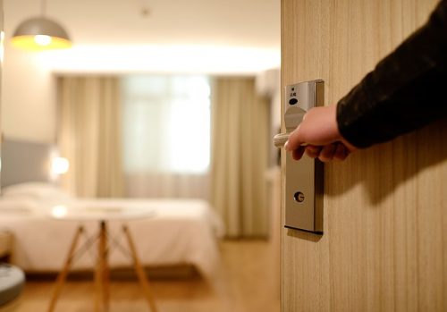 Quarto de hotel com fechadura magnética Pessoa abrindo a porta de um quarto de hotel
