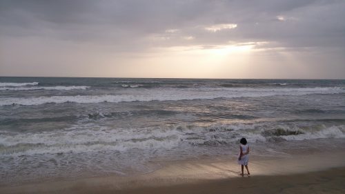 Turista na praia Turista em uma praia no fim da tarde
