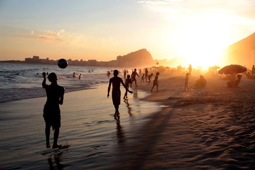 pessoas em praia carioca durante o Pôr do sol