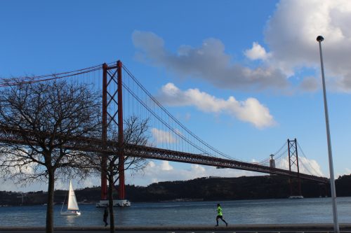 Arredores da Ponte 25 de Abril Praticantes de esporte próximos à Ponte 25 de Abril e ao Cristo Rei