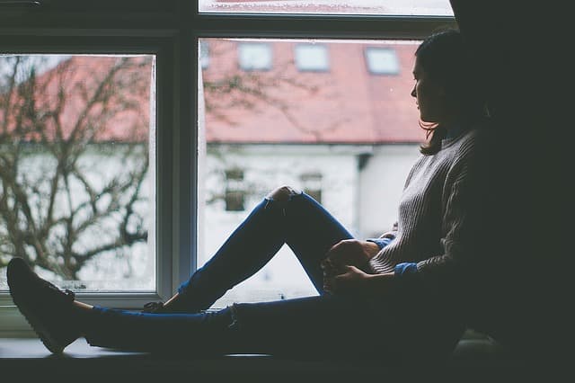 Mulher triste na janela Mulher triste olhando para a janela