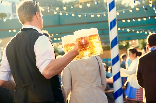 Home com canecas de cervejas na Oktoberfest Cerveja em festa alemã