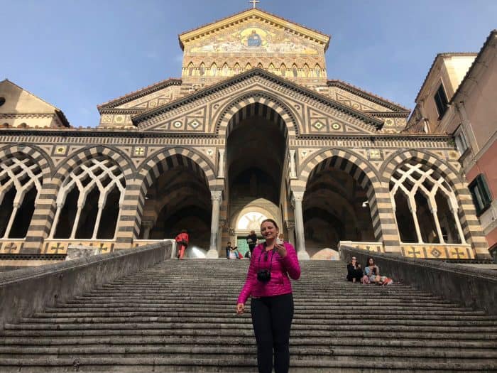 Frente de igreja em Amalfi e turista na escada