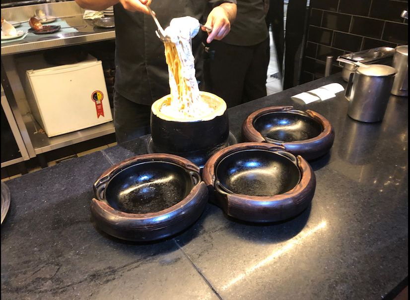Chef prepara macarrão dentro de um queijo parmesão