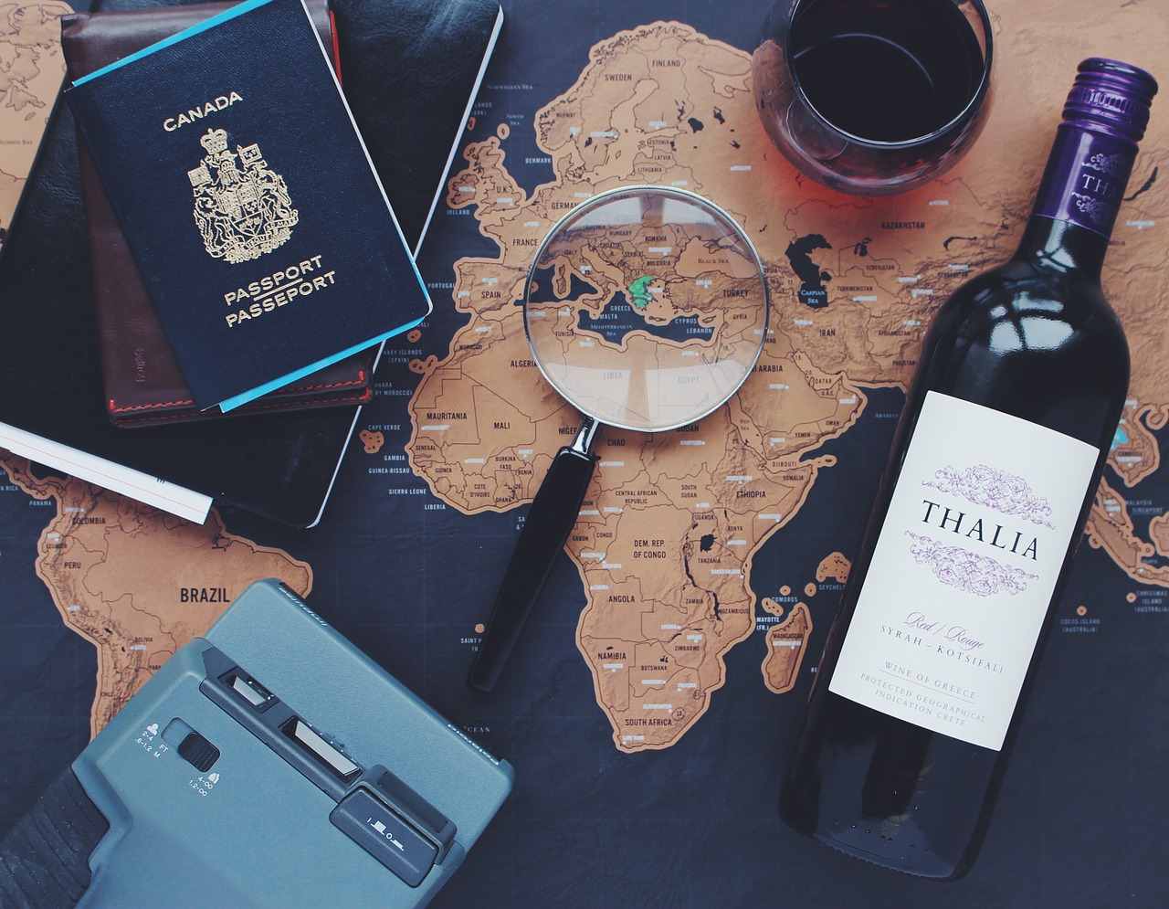 passaporte, garrafa de vinho, lupa e o mapa para tirar a próxima viagem do papel passaporte, garrafa de vinho, lupa e o mapa para tirar a próxima viagem do papel