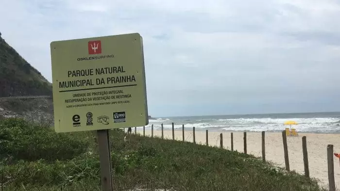 Placa e praia preservada ao fundo