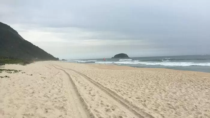 Paisagem com praia deserta e montanhas ao fundo
