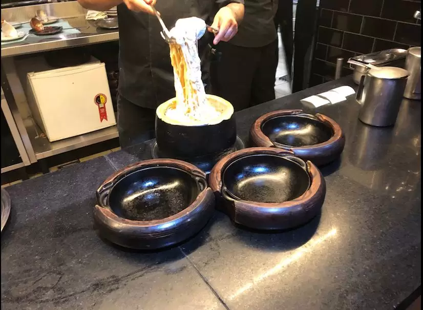 Chef prepara macarrão dentro de um queijo parmesão